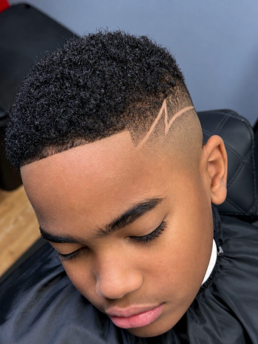 Kids curly fade with a lightning design at Eminence Barbersuite, North Plainfield NJ