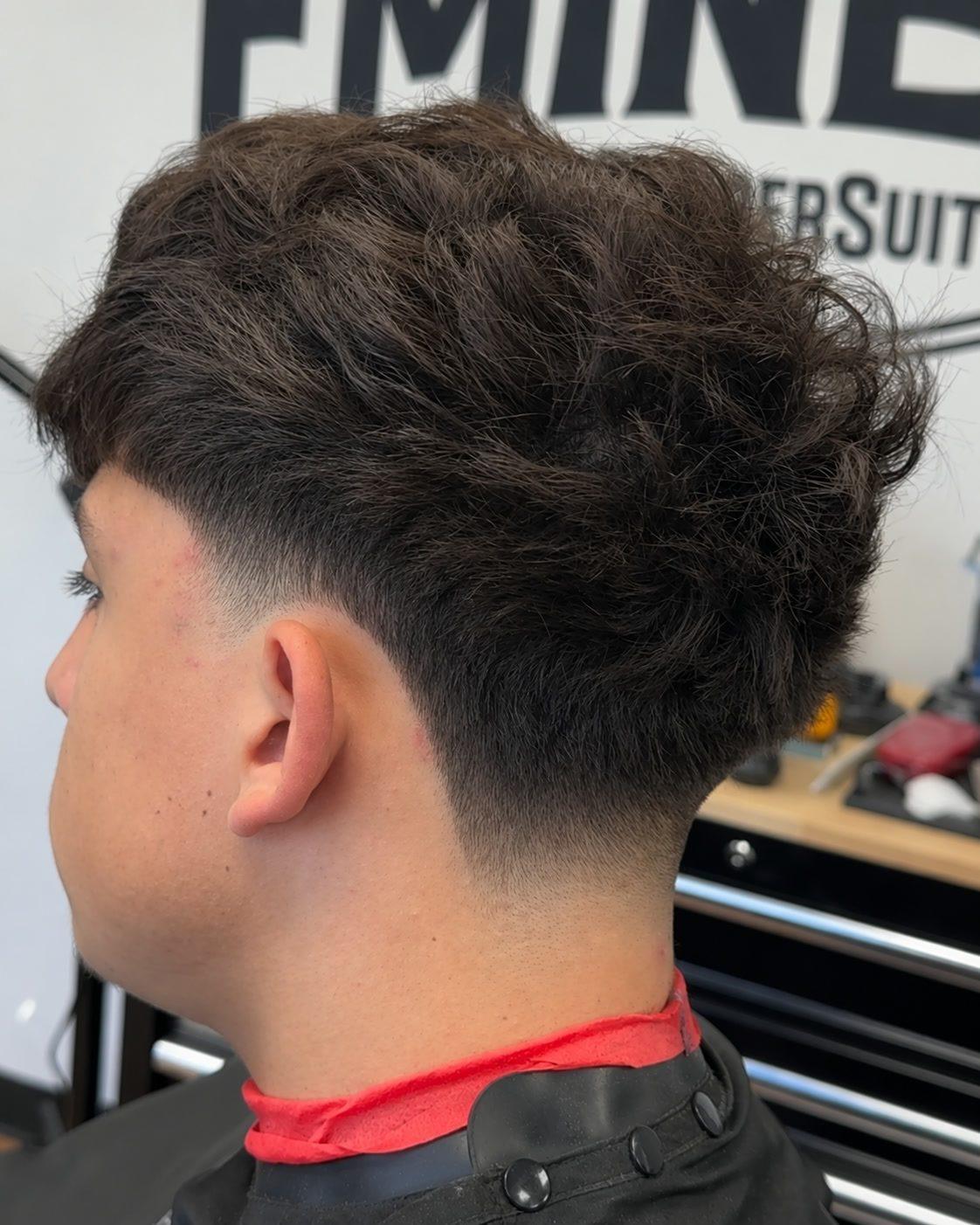 Mid taper fade with messy top at Eminence Barbersuite, North Plainfield NJ
